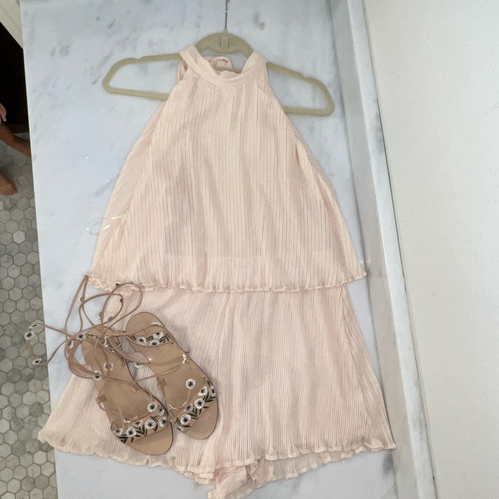 Adorable cream chiffon ruffle short romper with tie back. Open winged back.
